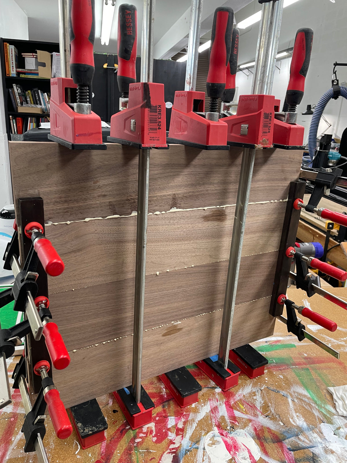 Black walnut boards clamped during glue-up for a 20 inch round serving board