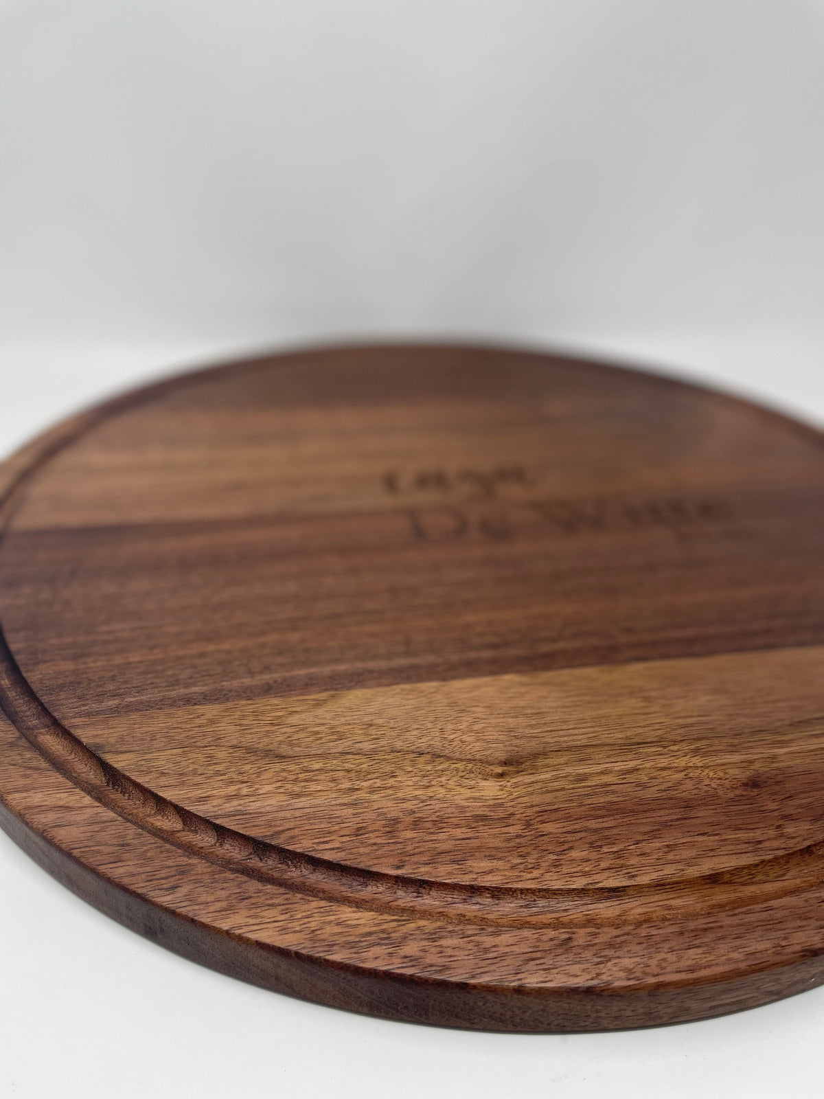 20 inch round black walnut serving board with juice groove engraved with a family name