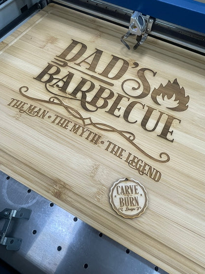 Bamboo cutting board engraved Dad's Barbecue The Man The Myth The Legend on the laser bed