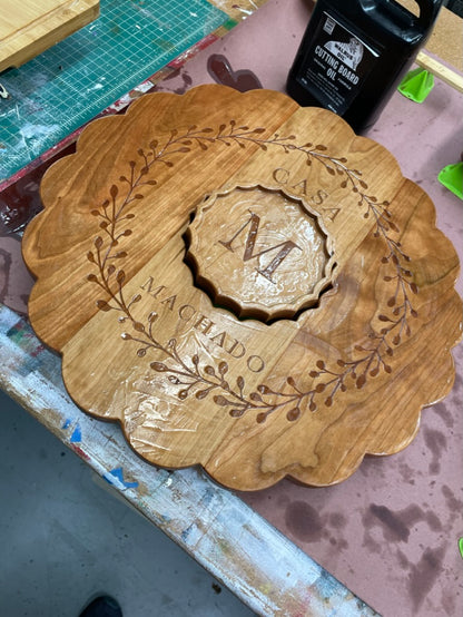 Cherry clamshell charcuterie board with engraved Casa Machado wreath, close-up
