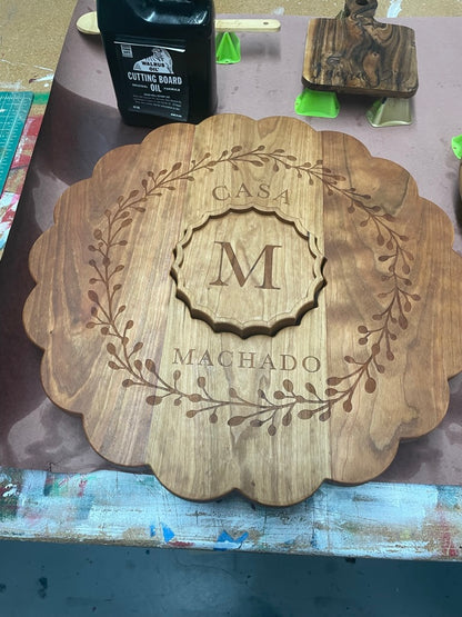 Cherry clamshell board engraved with an M monogram wreath, angled view