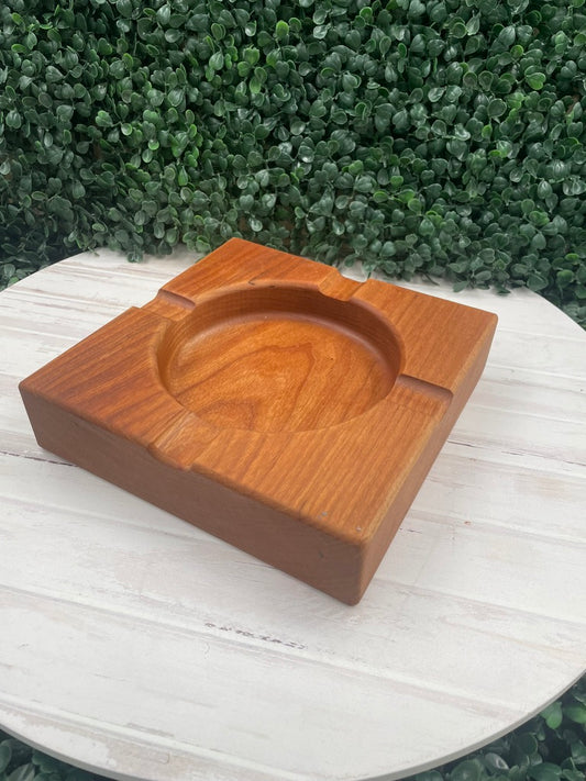 Cherry wood cigar ashtray, 7 x 7 inch, on a white table with greenery