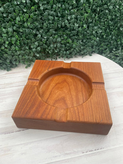Cherry wood cigar ashtray with deep center bowl on a white table