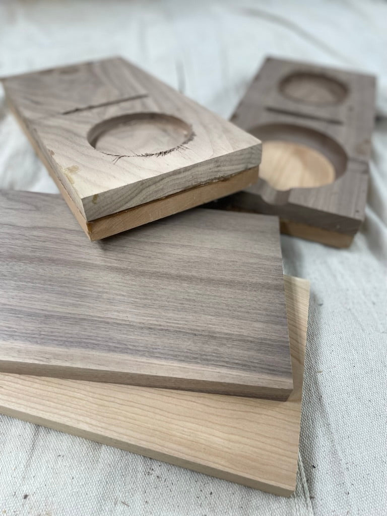 Cut wood blanks with cigar ashtray cutouts during production of the cigar gift set