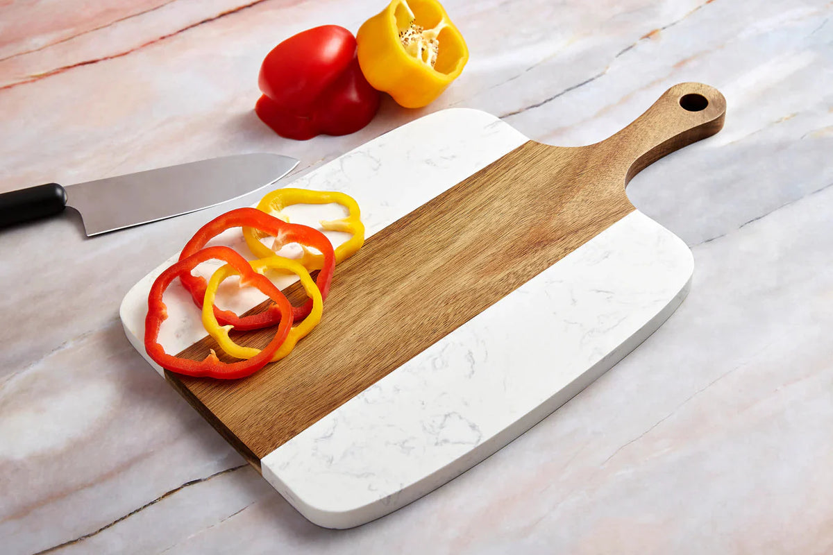 Marble and acacia serving board with handle styled with sliced peppers