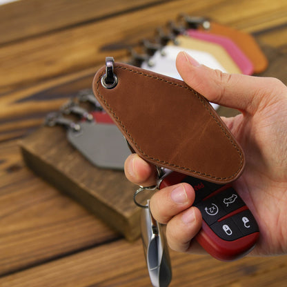 Rawhide leatherette motel keychain held in hand, size reference with car key