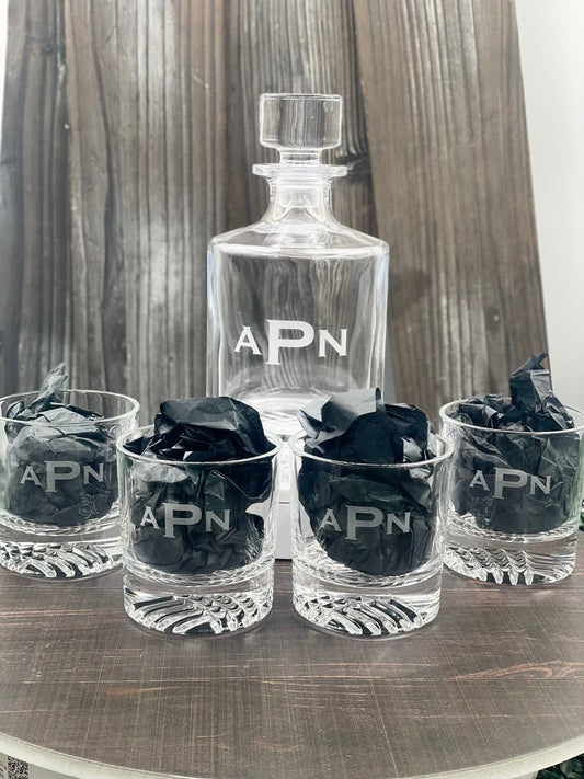 Round whiskey decanter and glasses engraved with the monogram APN