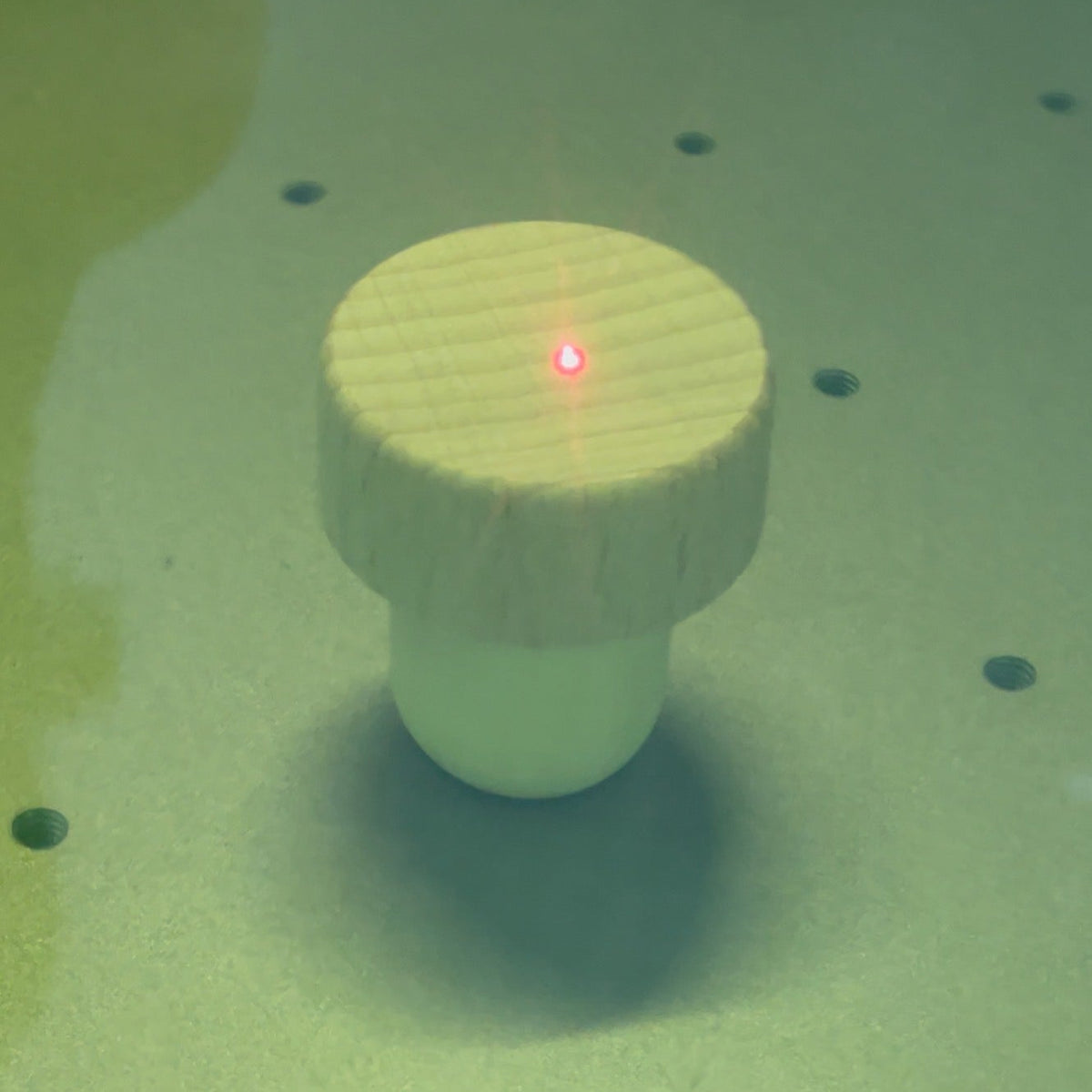 Wine cork under the laser engraver during custom engraving