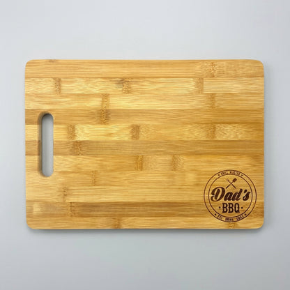 Small 9.75 x 13.75 inch bamboo cutting board engraved with a Dad's BBQ badge
